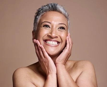 Middle age woman happily flaunting her smooth skin after microneedling